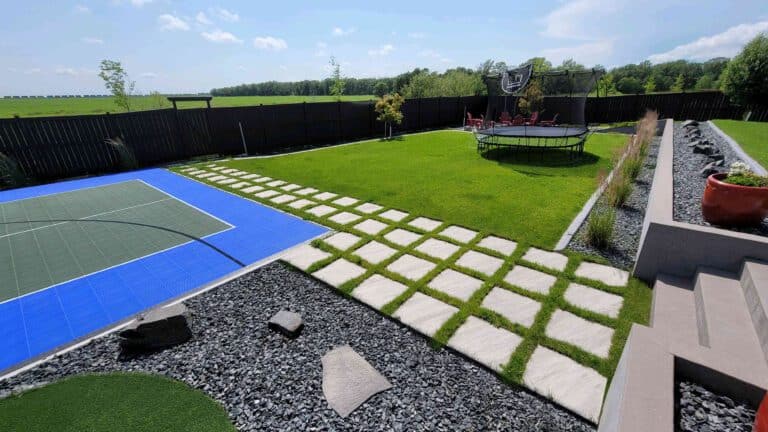 Outdoor design with grid paver walkway and synthetic turf lawn in Deerpoint yard