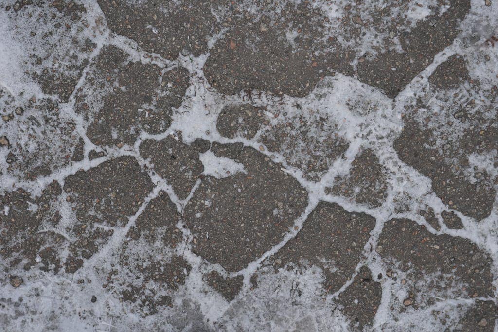 Close-up of a frosty cobblestone pavement, showcasing winter textures.