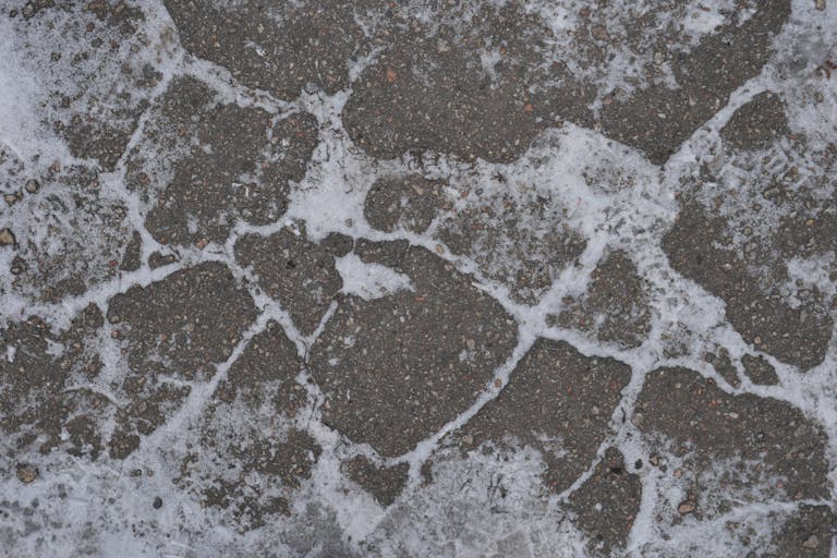 Close-up of a frosty cobblestone pavement, showcasing winter textures.